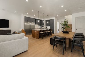 A modern kitchen with a central island, bar stools, and a dining area. - Six Keys 6 Bedroom Townhouse (St. George)