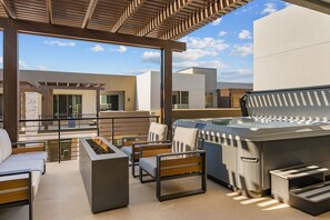 A rooftop patio with outdoor seating, a barbecue grill, and a hot tub. - Six Keys 6 Bedroom Townhouse (St. George)