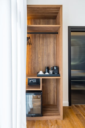 Eine moderne Küche mit Holzschränken, einer integrierten Kaffeemaschine und einem Kühl- und Gefrierschrank mit Glastür.
