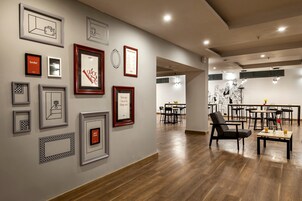 A modern interior with a dining area, wooden flooring, and various framed artworks on the walls.