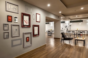 Un interior moderno con zona de comedor, suelo de madera y varias obras de arte enmarcadas en las paredes.