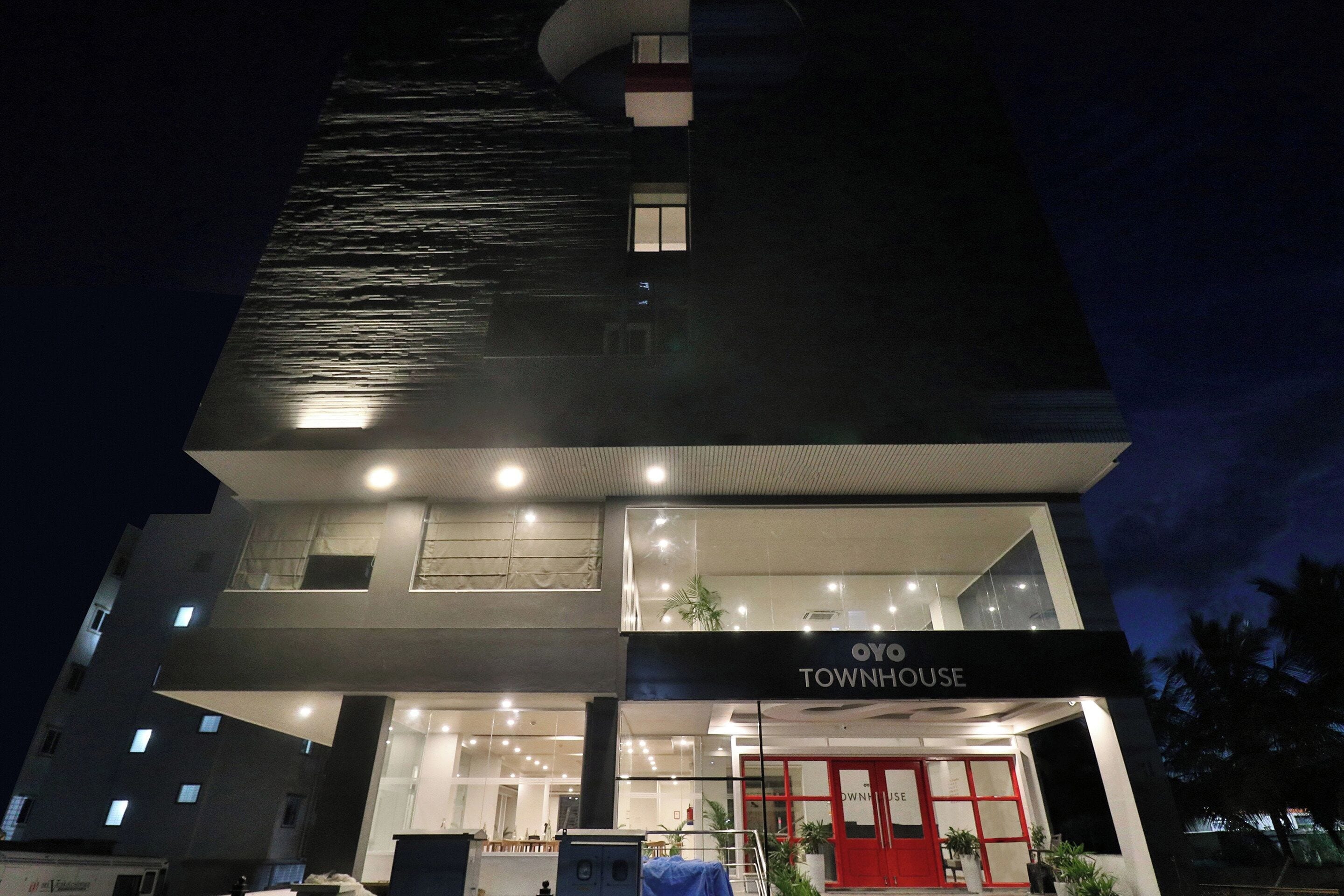 Un edificio moderno con un letrero que dice 'OWNHOUSE TOWNSHOUSE' en la entrada.