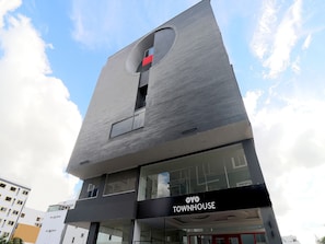 Un edifici modern amb un cartell ben visible de 'OYO TOWNHOUSE'.