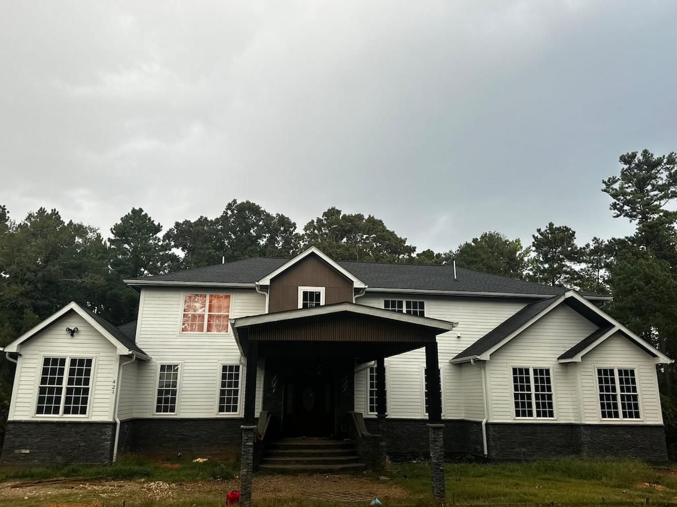 A two-story house with a covered porch and a front entrance.