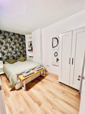 A bedroom with a bed, a bench, a wardrobe, and a wall with a letter art piece. - Live in Style in Madrid (Madrid)