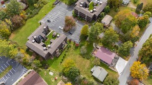 Vista aérea de una zona residencial con varios edificios, un estacionamiento y zonas verdes circundantes.
