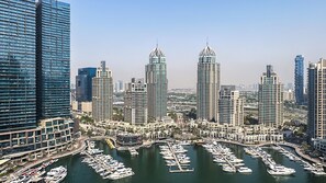 Ein Yachthafen mit zahlreichen angossenen Booten, umgeben von Hochhäusern mit moderner Architektur.