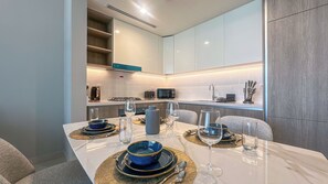 A modern kitchen with white cabinets, a built-in microwave, and a gas stove. - Chic full Dubai Marina View 1 BR apartment in LIV Marina (Dubai)
