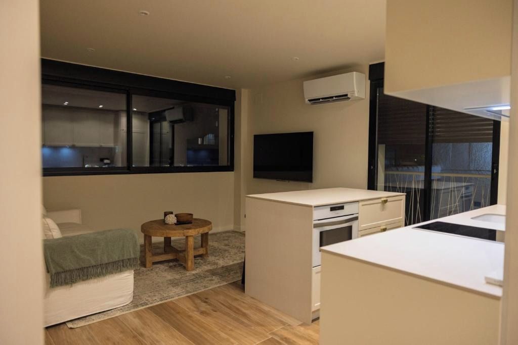 Un espacio habitable compacto con kitchenette, comedor y televisor.