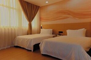 Quarto de hotel com duas camas, uma janela grande com cortinas e um mural na parede.