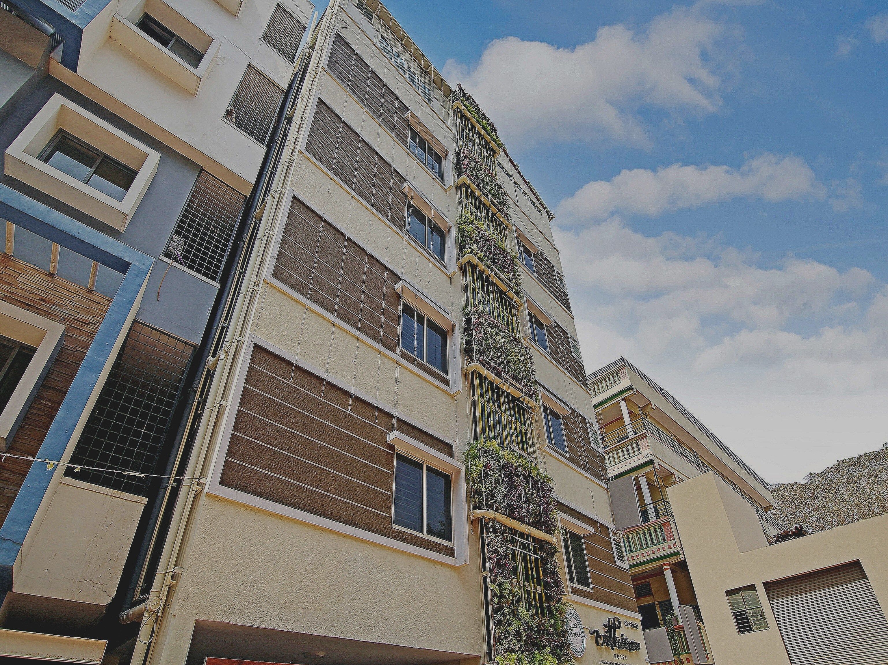 A multi-story residential building with balconies, large windows, and a clear sky.