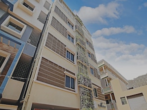 A multi-story residential building with balconies, large windows, and a clear sky. - Hotel O With Inn (Bangalore)
