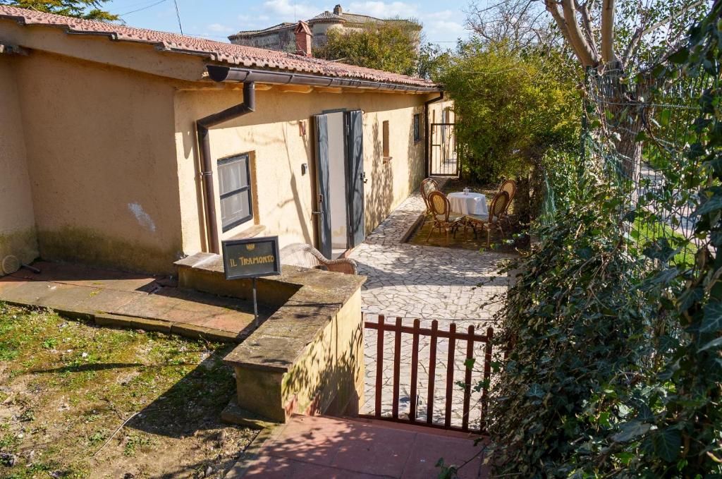 Un bâtiment avec un toit en tuiles, un chemin de pierre menant à une porte, et une enseigne indiquant la présence d’un restaurant.