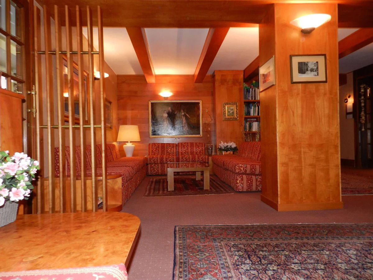 Una habitación acogedora con piso de madera, un sofá, una mesa y una estantería.