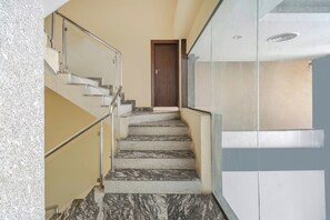 A staircase with marble steps and metal railings leading to a wooden door.