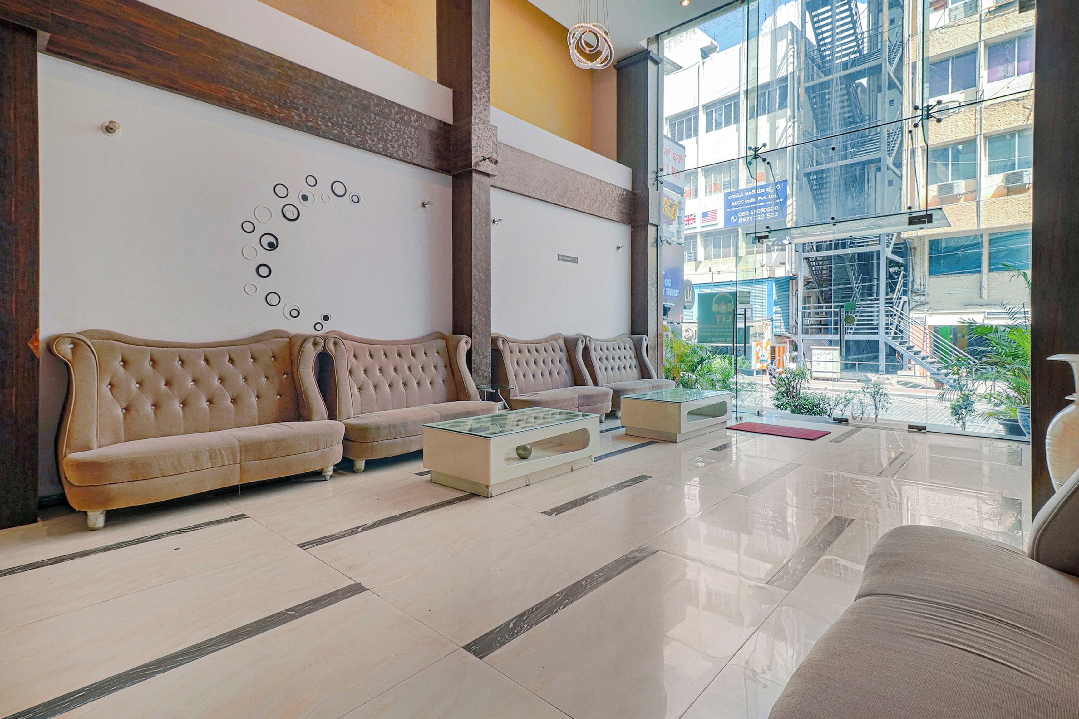 A lobby with a seating area, a reception desk, and a view of the outside.