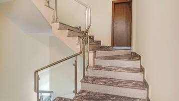 Una escalera con barandales de metal y una puerta de madera en la parte superior.