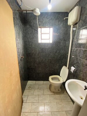 Un baño pequeño con inodoro, lavamanos y ventana.