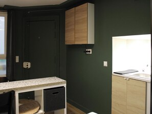 A kitchen with dark green walls, wooden cabinets, a granite countertop, and a window. - A cozy Paris — 2-minute walk from the metro (Paris)