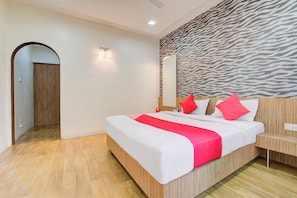 A hotel room with a bed, wooden headboard, a zebra-patterned wall, and a wooden floor. - Super Collection O Sunshine Near Inox (Pune)