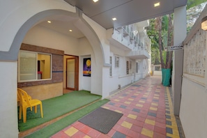 An indoor reception area with a tiled floor, a reception desk, and a yellow chair. - Super Collection O Sunshine Near Inox (Pune)