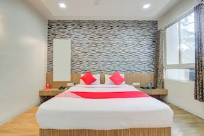 A hotel room with a large bed, a zebra-patterned wall, a window with curtains, and a wooden floor. - Super Collection O Sunshine Near Inox (Pune)