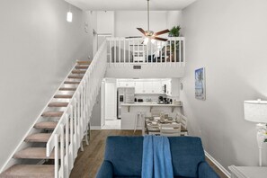 A modern interior with a staircase, a dining area, and a kitchen. - Sunny Fort Myers 2BR Condo | Pool & Hot Tub (Fort Myers)