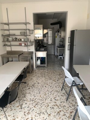 Een keuken met roestvrijstalen apparatuur, een granieten aanrechtblad en een puntgenaaid vloertje.