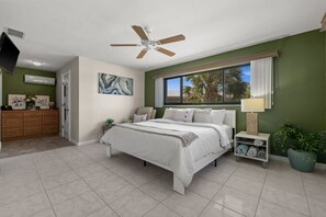 A bedroom with a bed, a nightstand, a ceiling fan, a window with a view, and a dresser. - Punta Gorda Isles| Optional Guest  House (Punta Gorda)