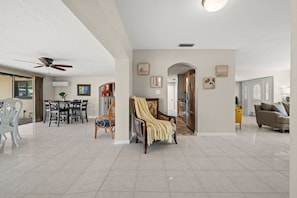 A spacious living area with a dining table, a sofa, and a chair. - Punta Gorda Isles| Optional Guest  House (Punta Gorda)