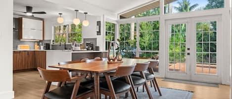 Una cocina moderna con comedor, ventanas amplias y vistas a zonas verdes.