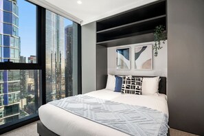 A modern bedroom with a large bed, city view, and abstract wall art. - Level 34 City View 2 Bedroom (Melbourne)
