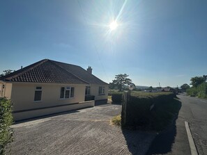 A residential property with a paved driveway, a detached house with a tiled roof, and a clear sky. - Honeycroft | Spacious Somerset Bungalow | Stunning Views | Dog Friendly (Rodney Stoke)