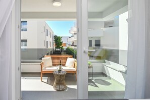 A modern balcony with a wooden sofa, a round wicker table, and a bottle of wine. - Apartment Smash with Private pool (Novalja)
