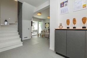 A modern interior with a staircase, a dining area, and a reception desk with decorative items. - Apartment Smash with Private pool (Novalja)