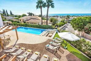 A rooftop pool area with lounge chairs, a small pool, and a view of the sea and surrounding buildings. - Villa Gardenia Vista (Albufeira)