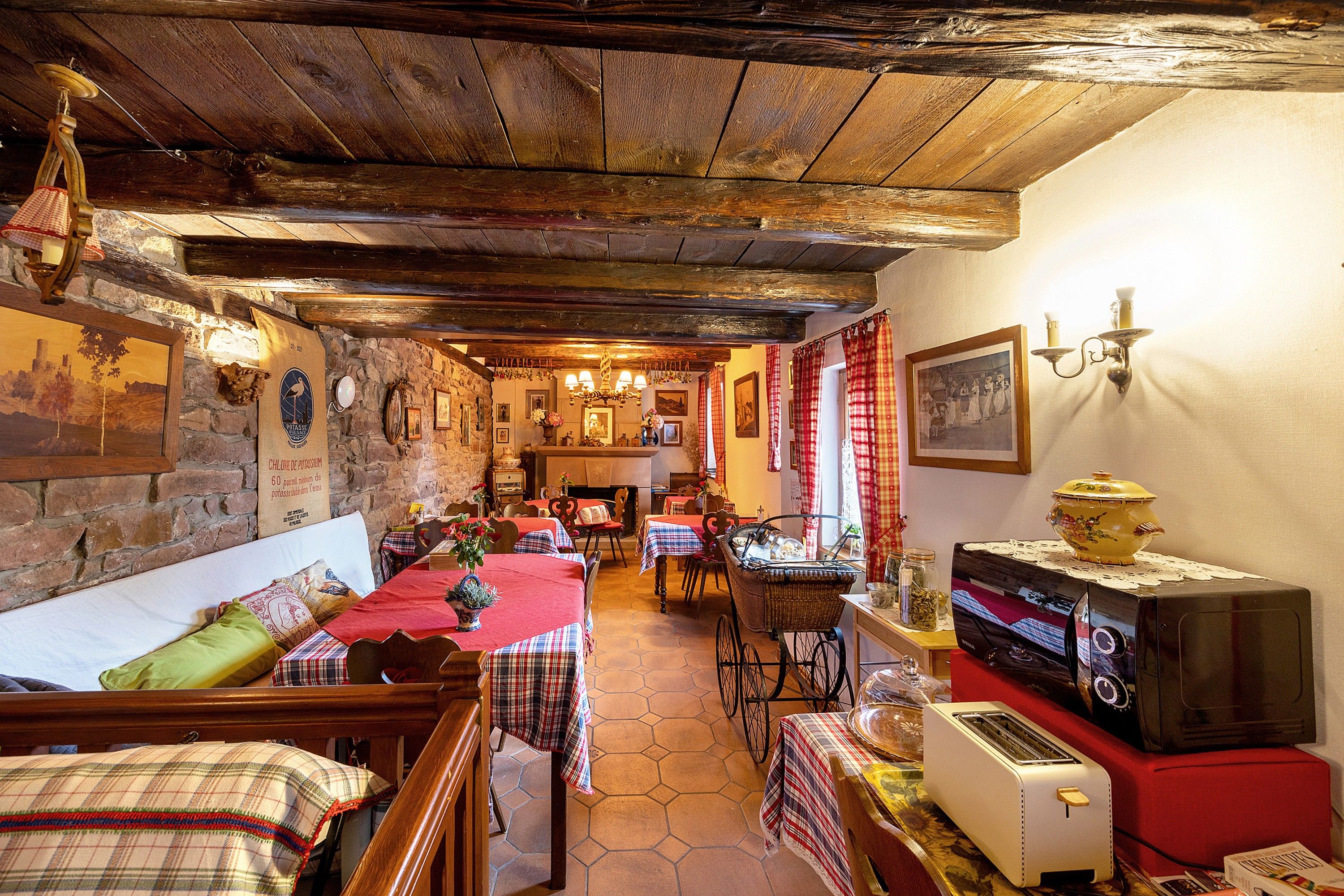 A rustic dining area with wooden beams, stone walls, and traditional decor.