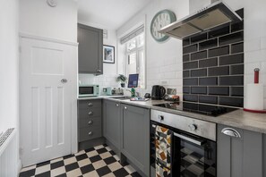 A kitchen with a microwave, toaster, kettle, and a built-in oven. - Hastings Buzz | By My Getaways (Hastings)