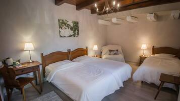 Une chambre d’hôtel avec deux lits, un bureau, une chaise et un lustre.