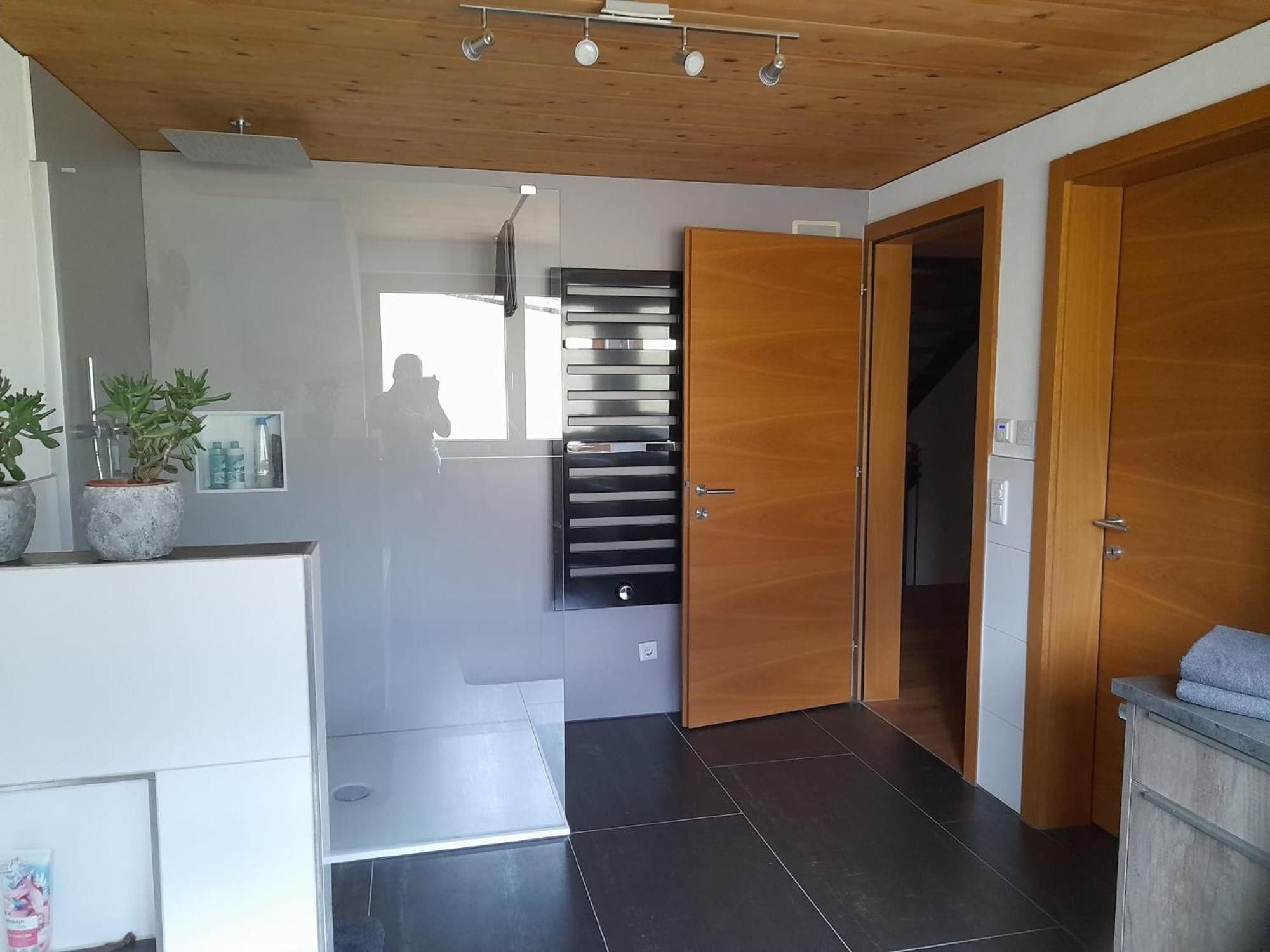 Un interior moderno con techo de madera, área de cocina integrada y un ventanal grande.