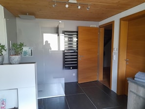 Un interior moderno con techo de madera, área de cocina integrada y un ventanal grande.