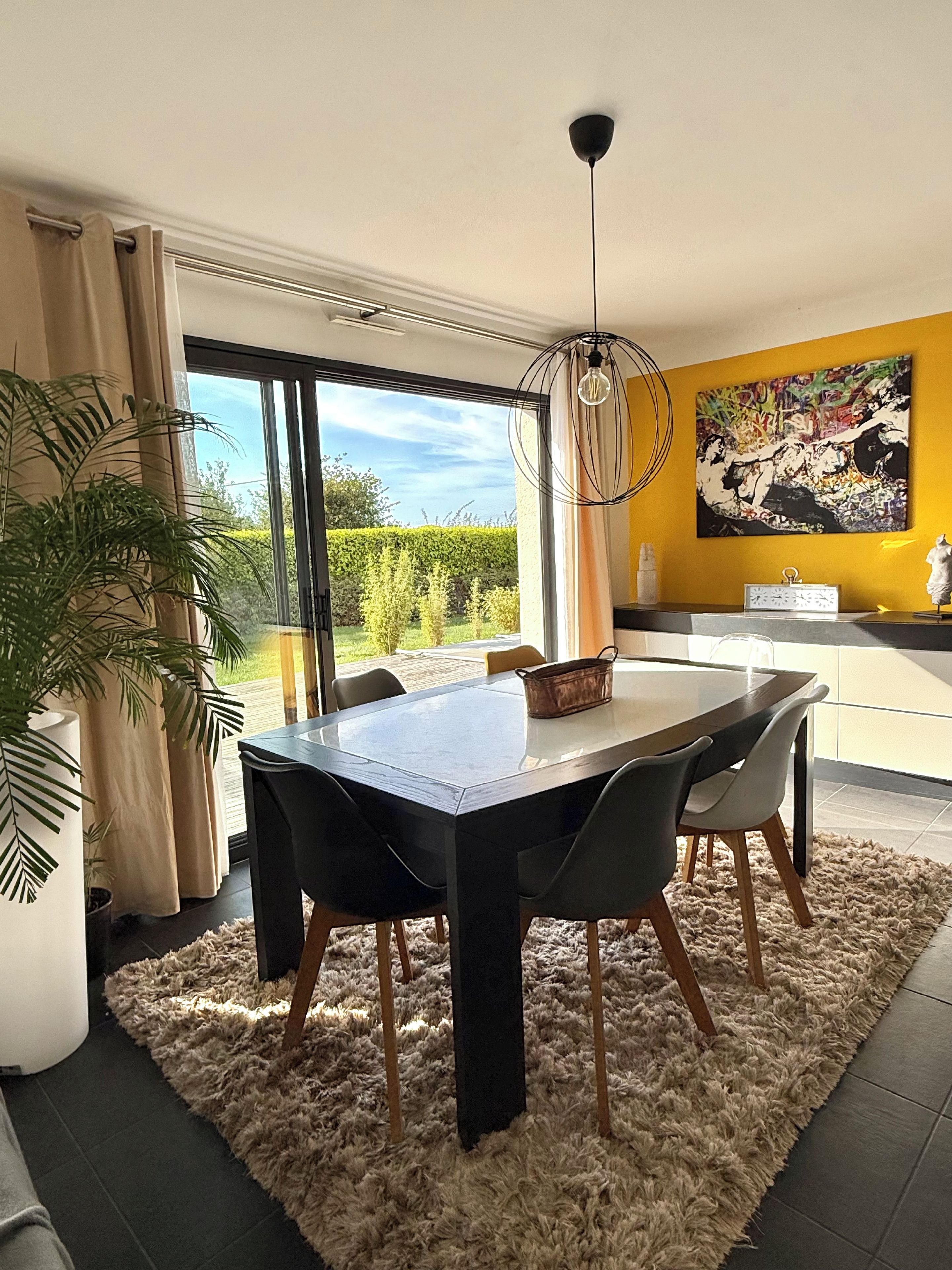Ein moderner Essbereich mit Tisch, Stühlen und Blick ins Freie.