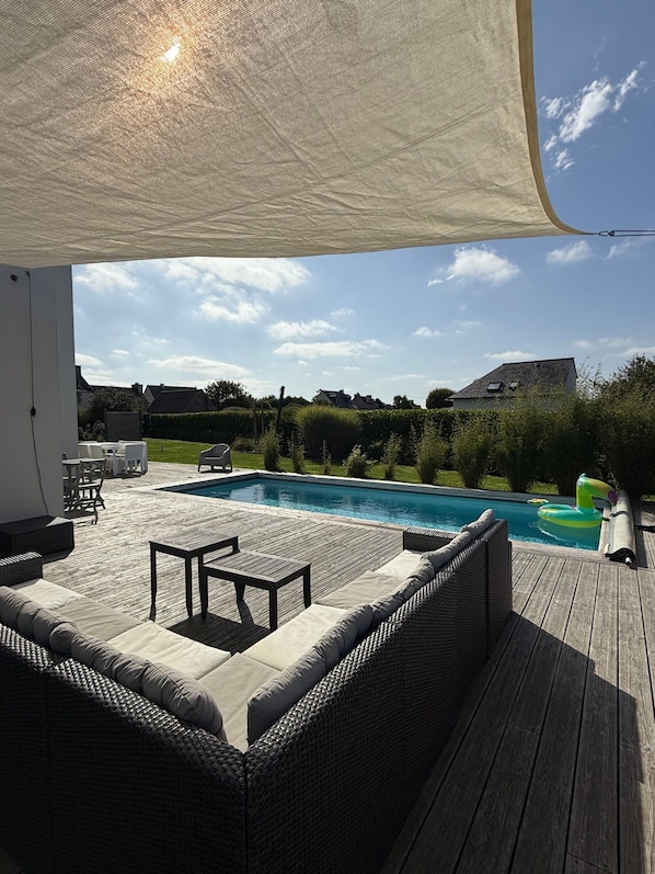 A poolside area with a covered seating area, a pool, and a view of the surrounding landscape. - Casa Isann—Pool—Ocean View & GR34 (Landéda)