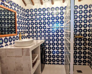 A bathroom with a sink, mirror, and shower area. - Villa Margarolo by gaiarooms (Morille)