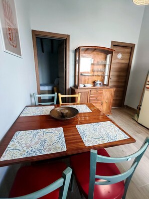 A dining area with a wooden table, floral placemats, and red chairs. - Villa Margarolo by gaiarooms (Morille)