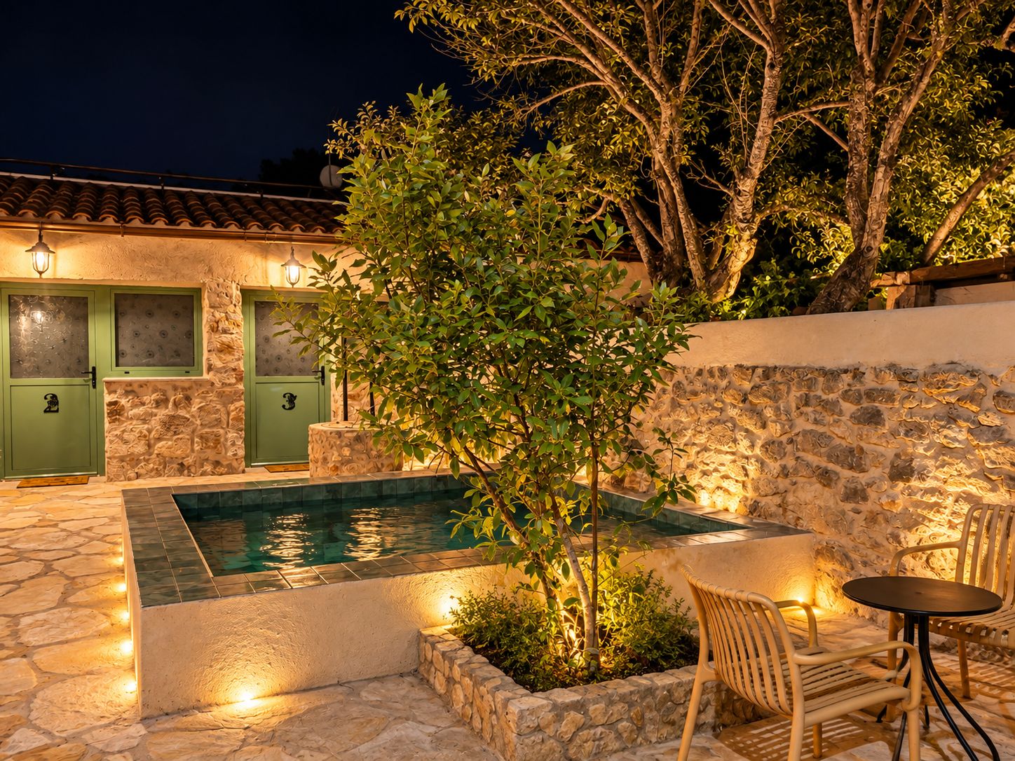 Una piscina de piedra con cubierta de madera, una puerta verde y un muro de piedra.