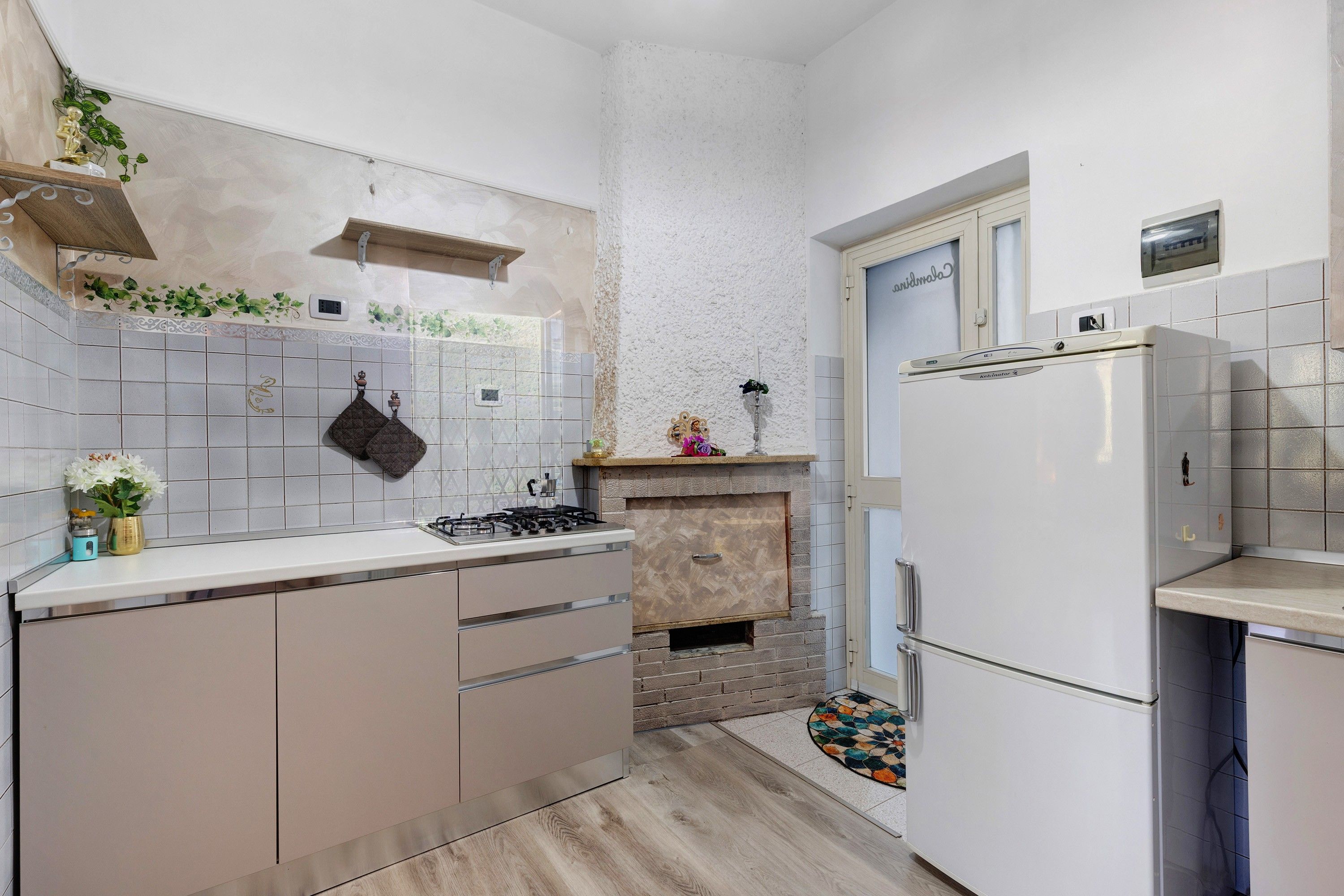 A compact kitchen with a gas stove, a built-in oven, and a refrigerator.