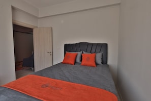 A bedroom with a bed, a door, and a visible closet. - H&M SUIT CAPPADOCIA (Merkez)