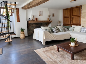 Een moderne woonkamer met een trap, een open haard en een bed met meerdere kussens.