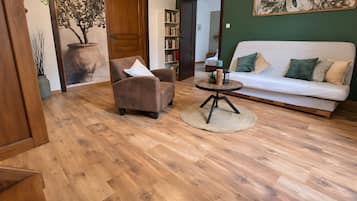 Ein Wohnzimmer mit einer Couch, einem Sessel und einem runden Couchtisch.